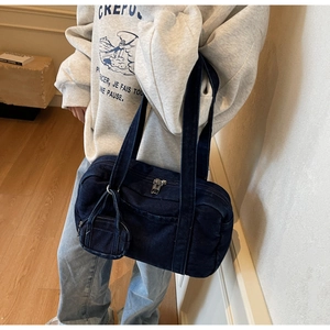 Dettaglio della borsa a spalla in denim blu con mini portamonete e doppia cerniera