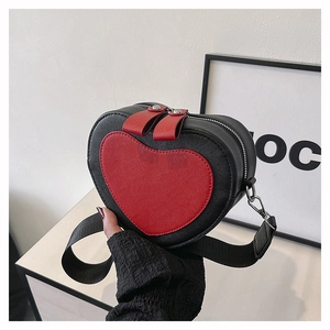 Detailed close-up of heart-shaped crossbody bag with red zipper and silver metal hardware