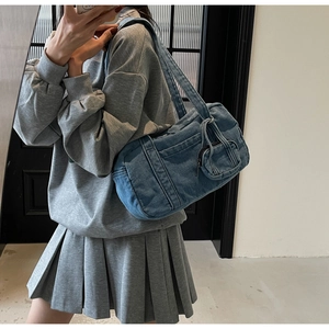 Dettaglio della borsa a spalla casual in denim blu con cerniere e fibbie laterali