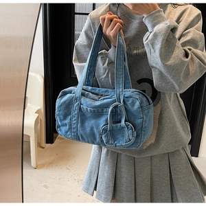Dettaglio della borsa a cilindro in denim vintage con pochette coordinata in blu