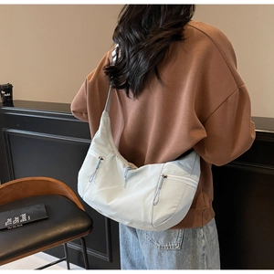 Detailed view of the light blue hobo bag showing side zippers and wide shoulder strap