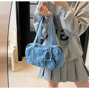 Dettaglio della borsa hobo in denim blu con mini portamonete in un set lifestyle