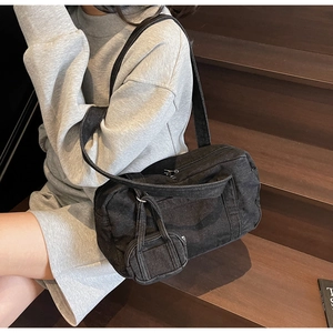 Dettaglio della borsa bowling in denim vintage con tasca frontale e mini custodia abbinata