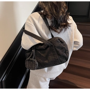 Dettaglio borsa boston in denim nero con mini pochette e tracolla lunga