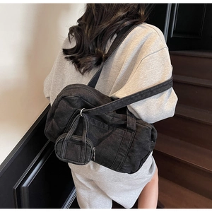 Dettaglio della borsa in denim nero vista da dietro con mini custodia sulla tracolla