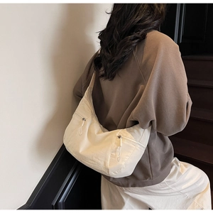Detailed view of cream crescent bag with double zipper pockets for daily use