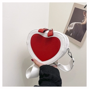Detail of heart-shaped crossbody bag with red patch and adjustable wide strap