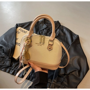 Detailed view of the shell-shaped crossbody bag with dual zippers and logo