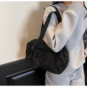 Dettaglio borsa a tracolla in denim nero con mini portamonete rotondo funzionale