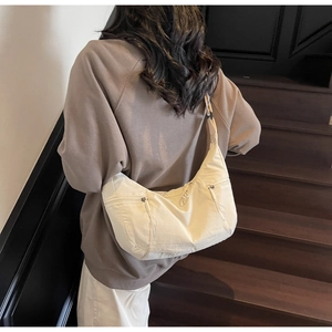 Detail of off-white large crescent crossbody bag on model back with zipper texture