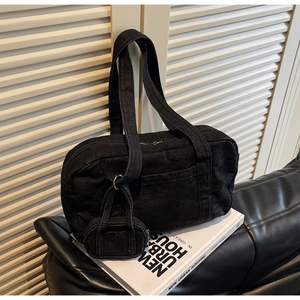 Dettaglio macro della borsa a spalla in denim nero con mini astuccio con cerniera coordinato