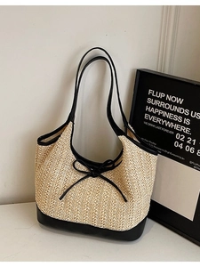 Minimalist beige straw tote bag with black leather trim and bow detail for women