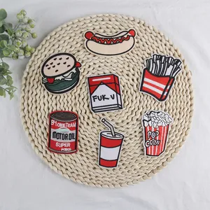 Detail of embroidered fast food patches including burger and fries on woven mat