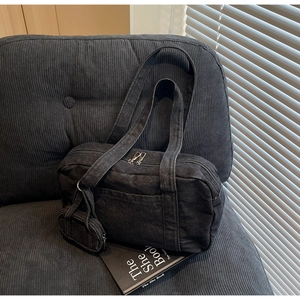 Dettaglio borsa bowling in denim nero con doppia zip e mini portamonete coordinato