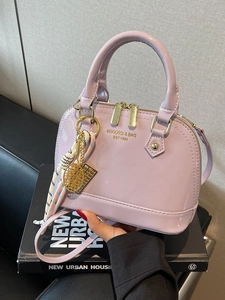 Chic light purple shell-shaped handbag in glossy patent leather with top handles
