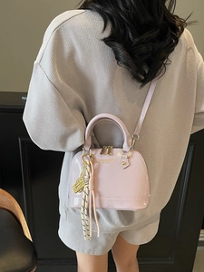 Chic lavender shell-shaped handbag in glossy patent leather with metal handle and strap