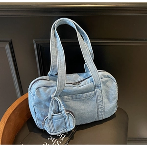 Dettaglio del denim azzurro della borsa Boston con mini portamonete su sedile in pelle