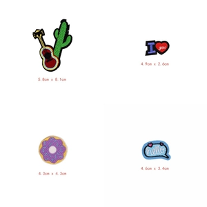 Détail de quatre écussons brodés colorés montrant une guitare, un cœur, un donut et hello