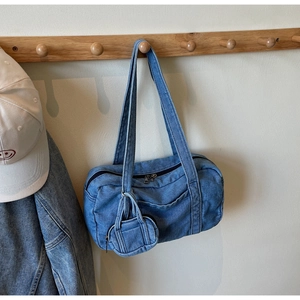 Dettaglio della borsa a spalla in denim lavato con mini portamonete e zip di chiusura