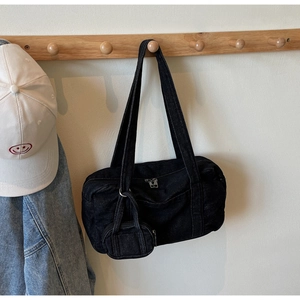 Dettaglio borsa a spalla in denim nero con mini portamonete su appendino in legno