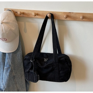 Dettaglio della borsa a spalla in denim nero con texture di alta qualità e mini pochette