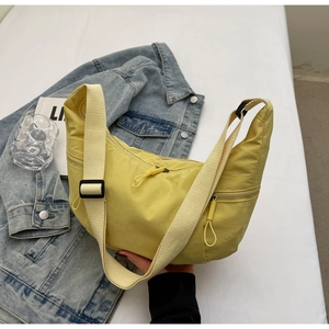 Detail of bright yellow crescent bag showing wide strap and nylon fabric texture