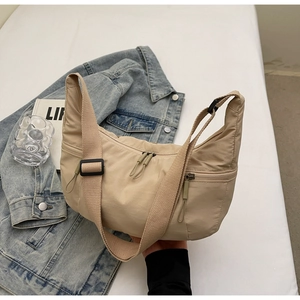 Detailed view of beige nylon dumpling bag showing water-resistant fabric and zippers