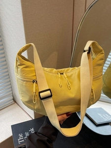 Lightweight bright yellow nylon crescent crossbody bag with adjustable strap and dual zippers