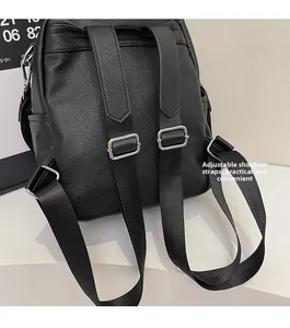 Detail of adjustable black leather backpack straps with silver buckles and texture
