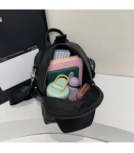 Internal view of the black leather backpack showing a tablet, bottle, and umbrella