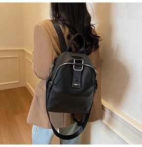 Rear view of a model wearing a black pebbled leather backpack for travel and daily use