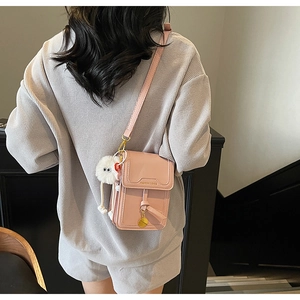 Pink matte leather crossbody phone bag with fashion embossing and a cute fur ball charm
