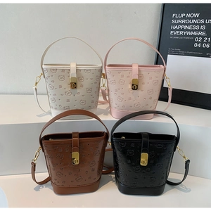 Detailed view of bucket bags in four colors with cute bear embossing and gold lock