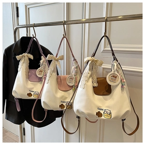 Vue détaillée de la broderie animale et du nœud en dentelle sur le sac à main Hobo blanc