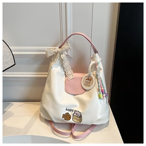 Détail du sac en cuir blanc et rose avec nœud en dentelle et pampilles colorées
