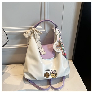 Détail du sac blanc et violet avec nœud en dentelle, pompons et imprimés Capybara