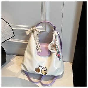 Gros plan du sac cabas crème et lilas avec nœud en dentelle et breloque capybara