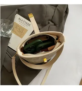Interior view of cream leather bucket bag showing large capacity for phone and cosmetics