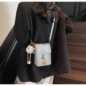 Chic silver metallic mini crossbody bag with a plush charm and fashion typography detail
