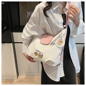 Détail du sac fourre-tout blanc et rose avec imprimé ours et breloque capybara