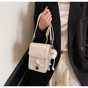 Detail of cream square crossbody phone bag with gold lettering and colorful chain strap