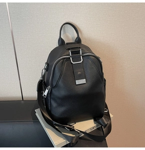 Close-up of black pebbled leather backpack with silver zippers and adjustable textile straps
