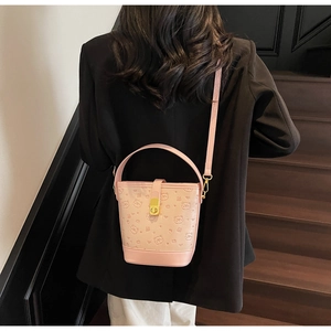 Detail view of pink bucket bag with embossed cartoon bear and adjustable strap