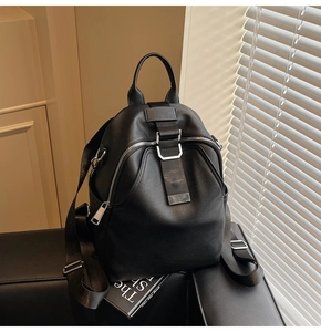 Side view of black pebble leather backpack featuring silver buckles and nylon straps