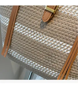 Close-up of bohemian woven bag texture with leather strap and golden buckle detail