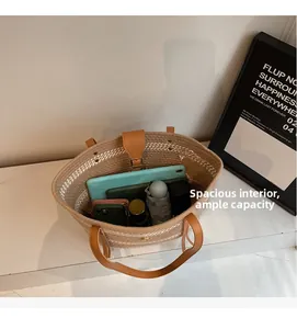 Top view of spacious straw tote bag interior holding a tablet, umbrella, and makeup items