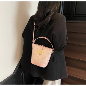Detailed side view of pink bucket bag with embossed bear patterns and metal lock