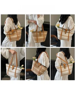 Detail of straw tote bag with leather straps, fringe tassels and woven stripes
