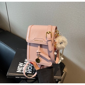 Detail of pink glossy phone bag with fashion gold lettering and white plush charm