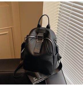 Detail of black pebbled leather backpack with metal buckle and woven strap detail